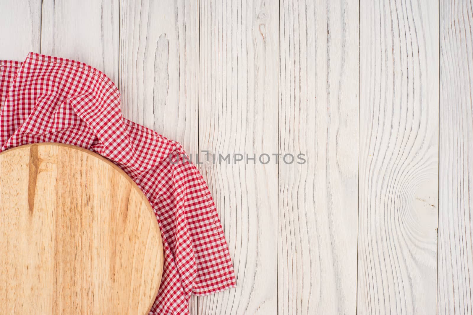 Cutting board on a kitchen napkin on old wooden table.  by DGolbay