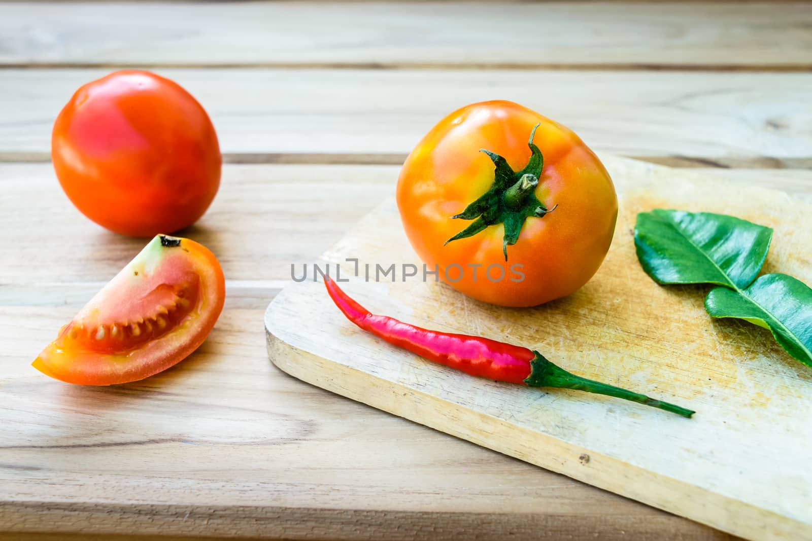 Tomatoes on chopping board with wooden