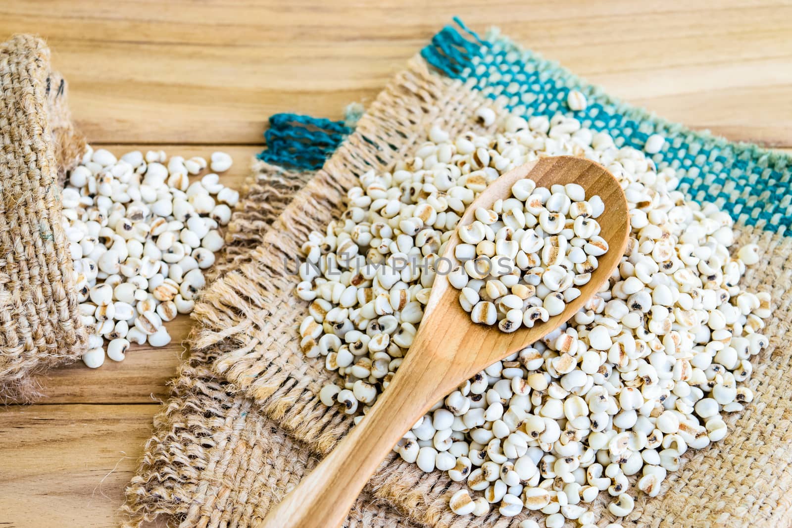 Job's tear seed dried in wooden spoon on wooden table