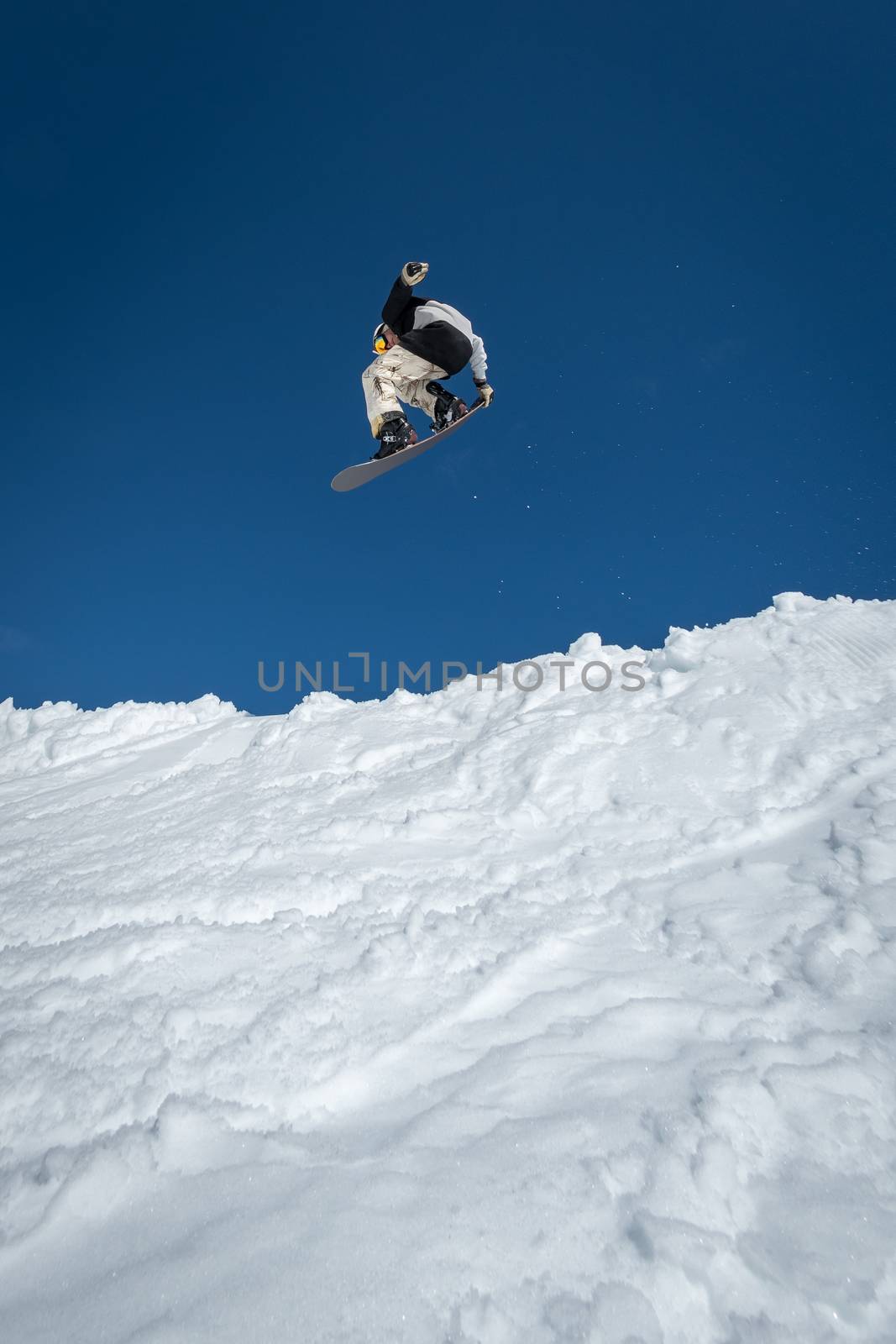 Snowboarder jumping against blue sky by homydesign