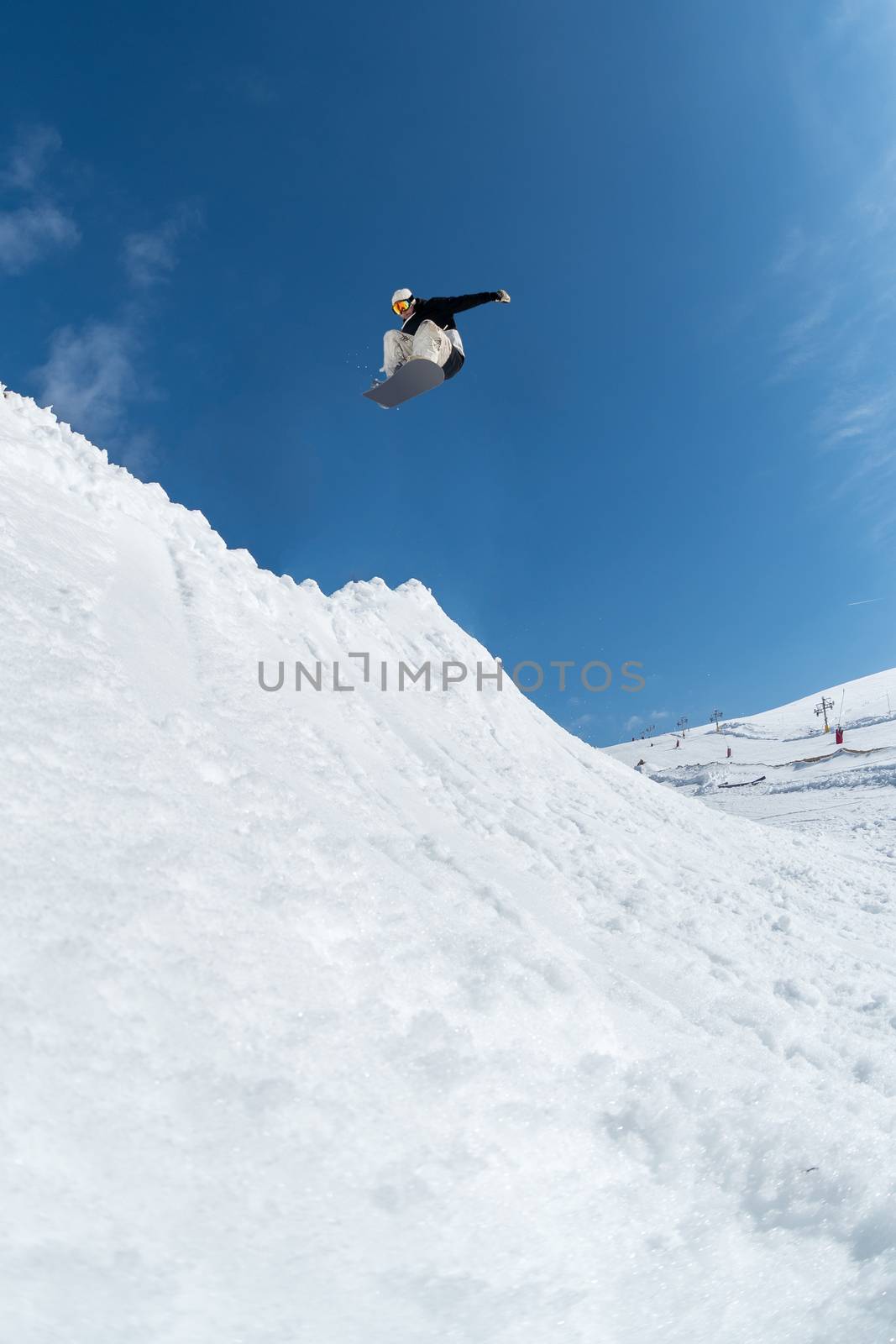 Snowboarder executing a radical jump against blue sky.