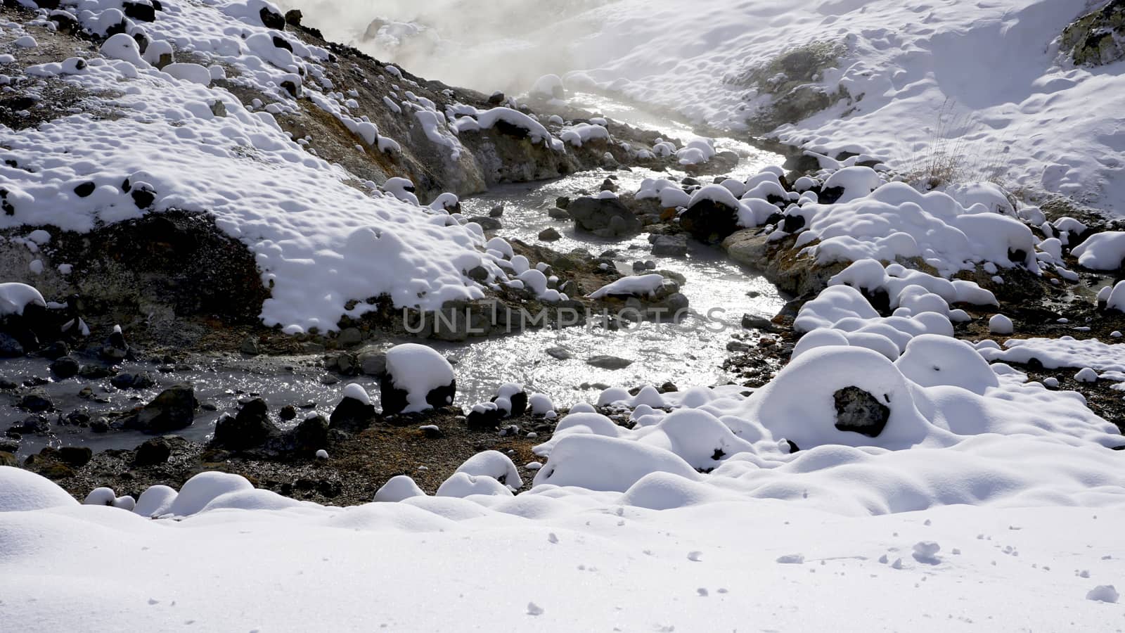 Closeup stone and stream in the mist Noboribetsu onsen snow winter national park in Jigokudani, Hokkaido, Japan