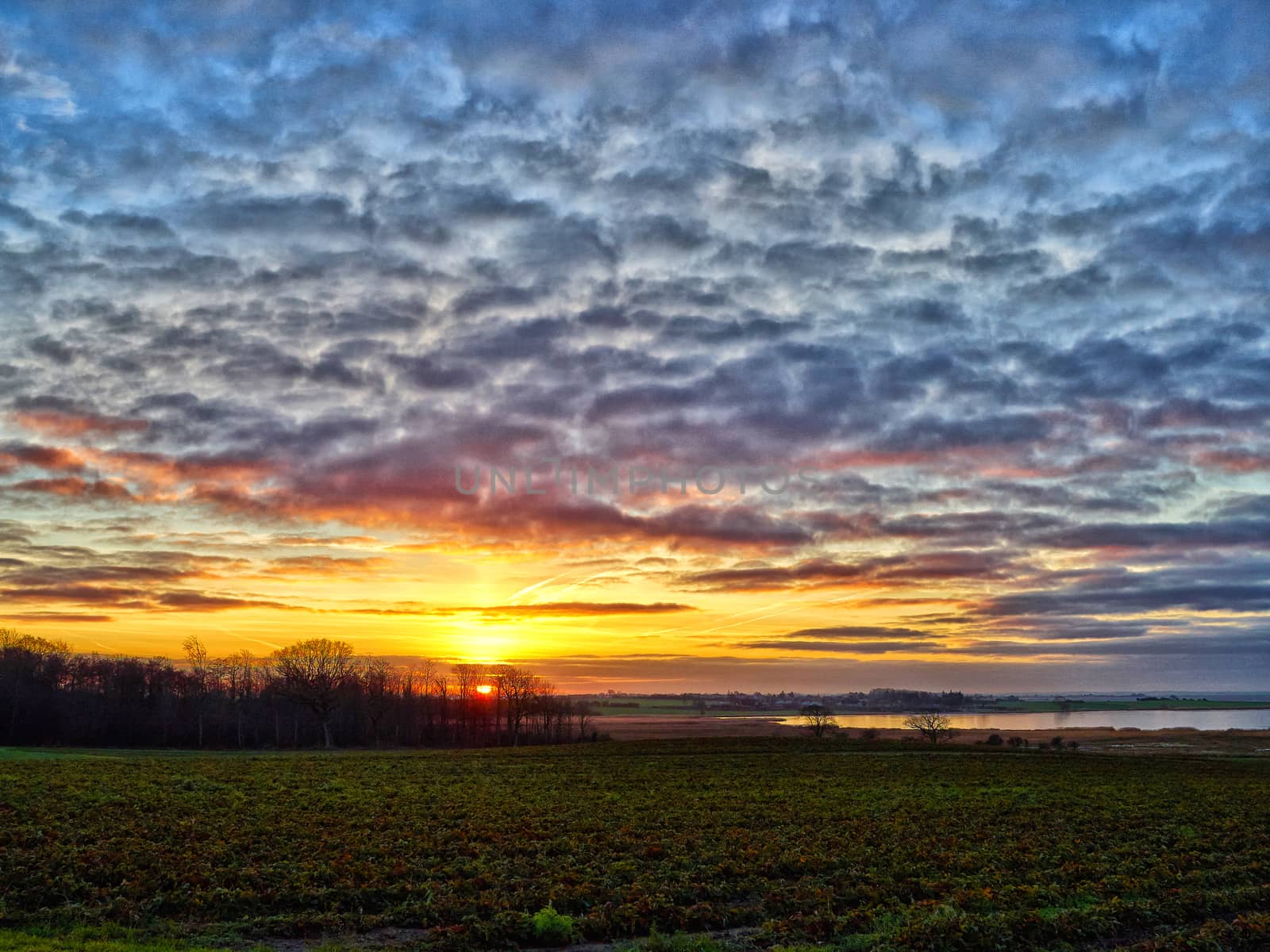 Landscape of green fields and a dramatic sunset by Ronyzmbow