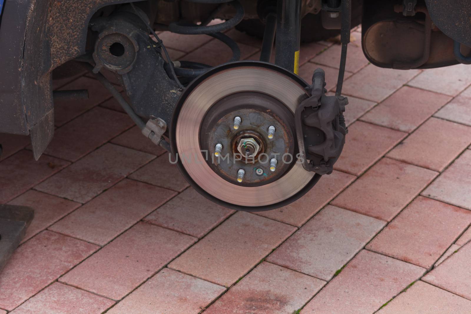 Disk brake on a car here Mechanic at the car brake repair in a car service workshop
