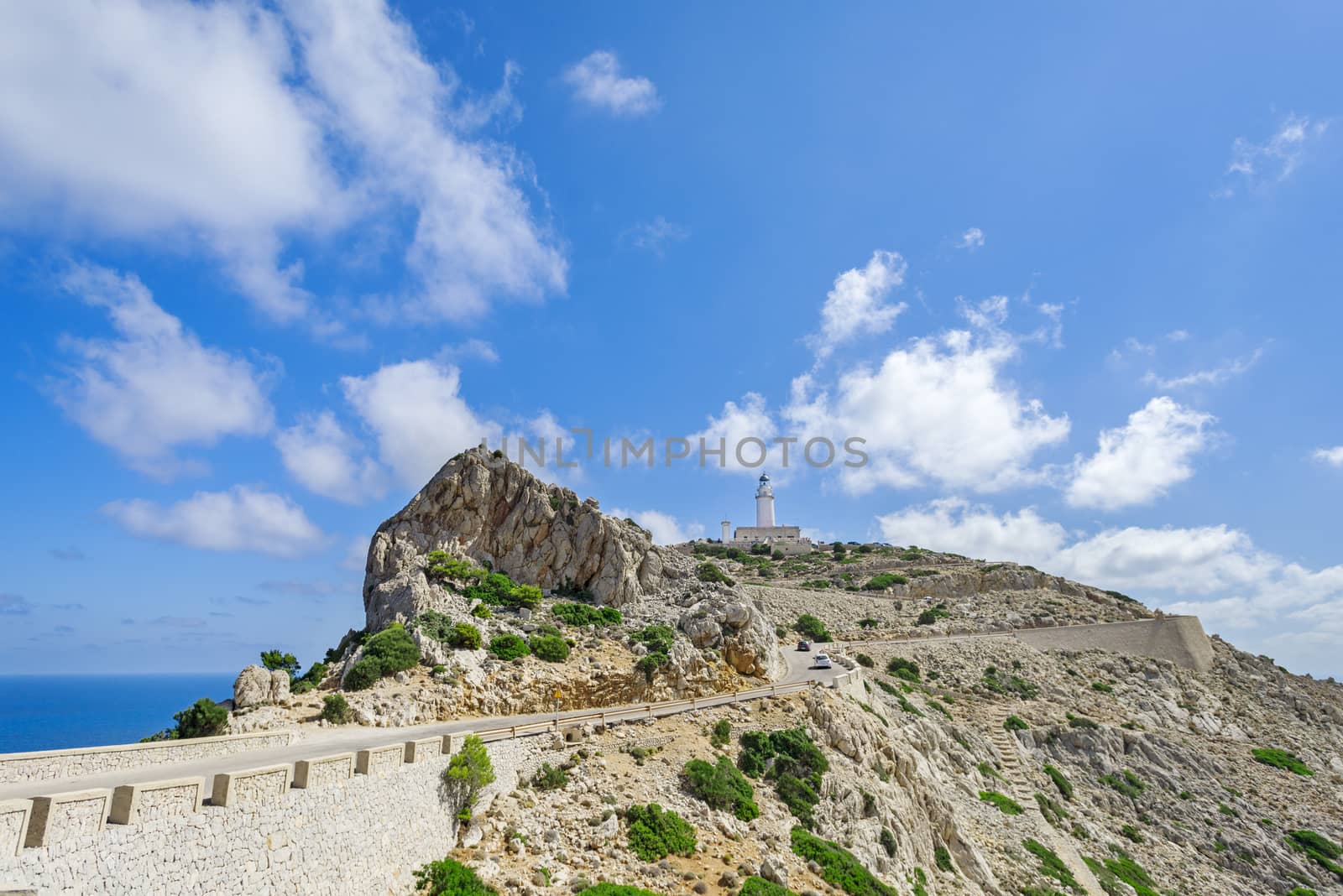 Famous Cap de Formentor, cliff on the northern part of Mallorca island, Spain. Big rocky mountains with lighthous in distance. Tourist destination.