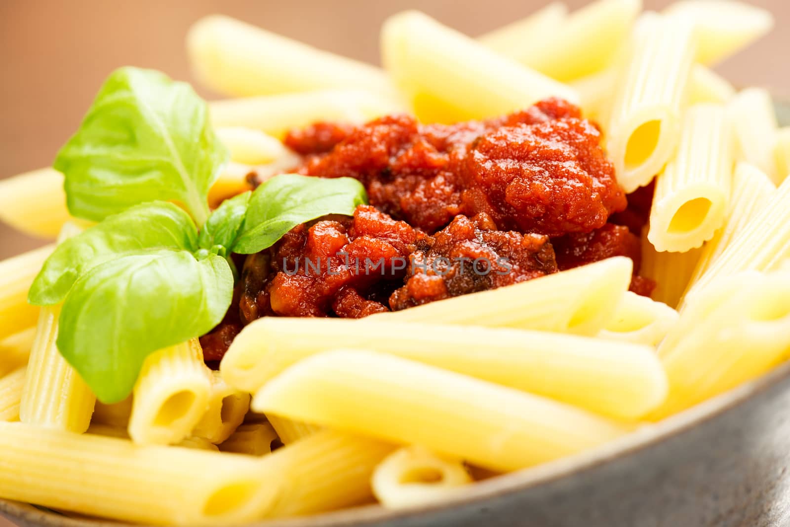 Penne pasta with a tomato bolognese beef sauce on the table macro
