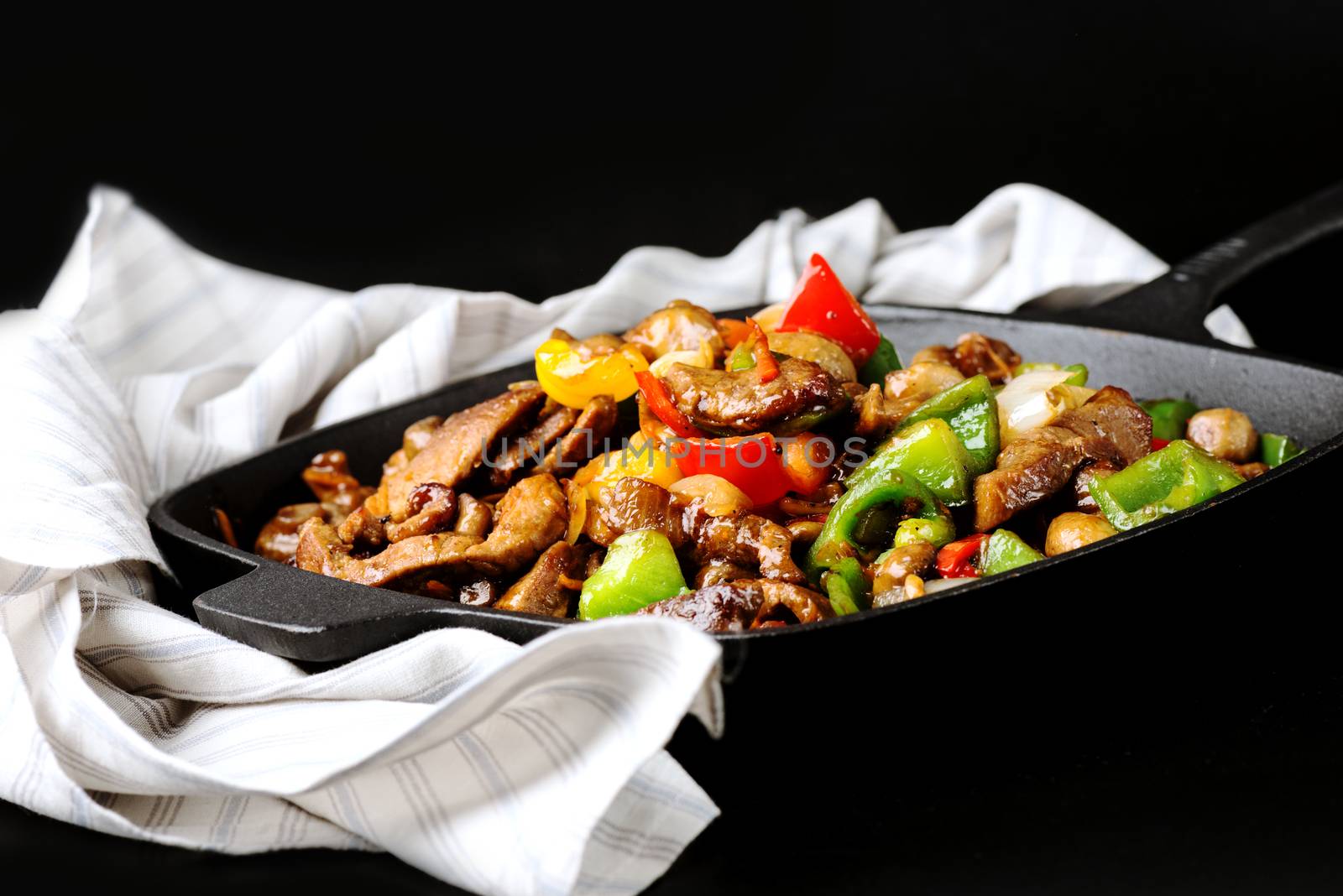 Iron cast skillet with meat and vegetables