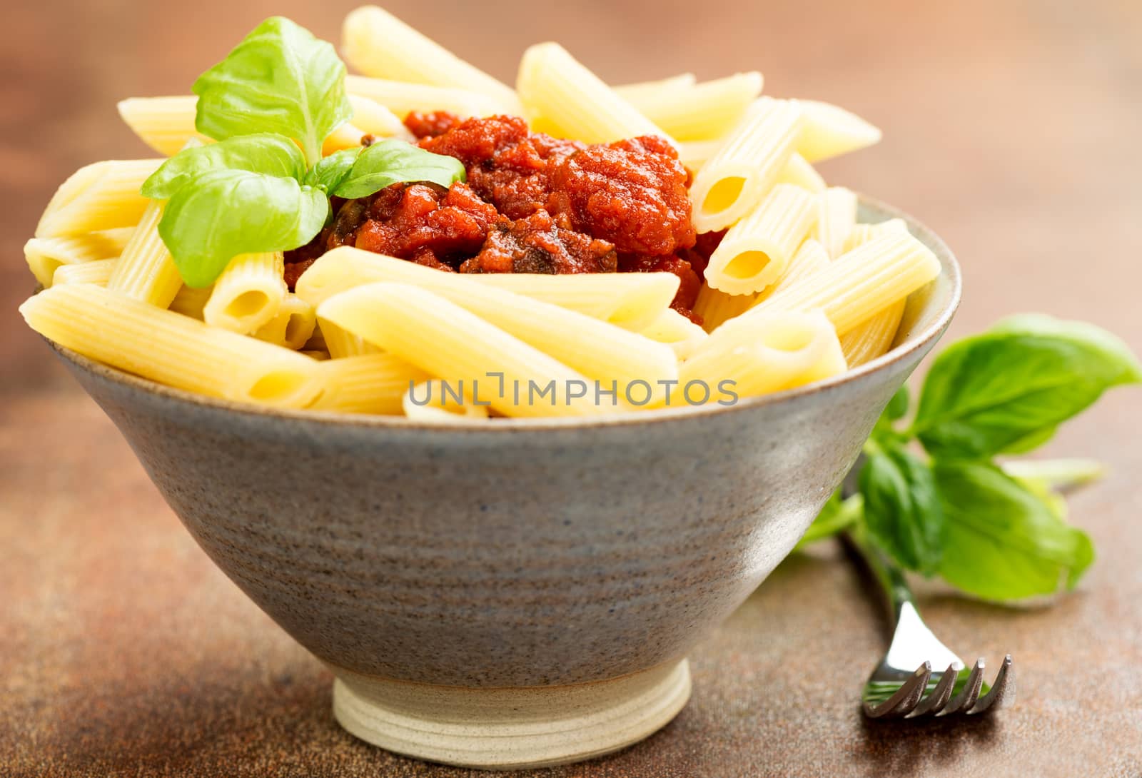 Penne pasta with a tomato bolognese beef sauce on the table