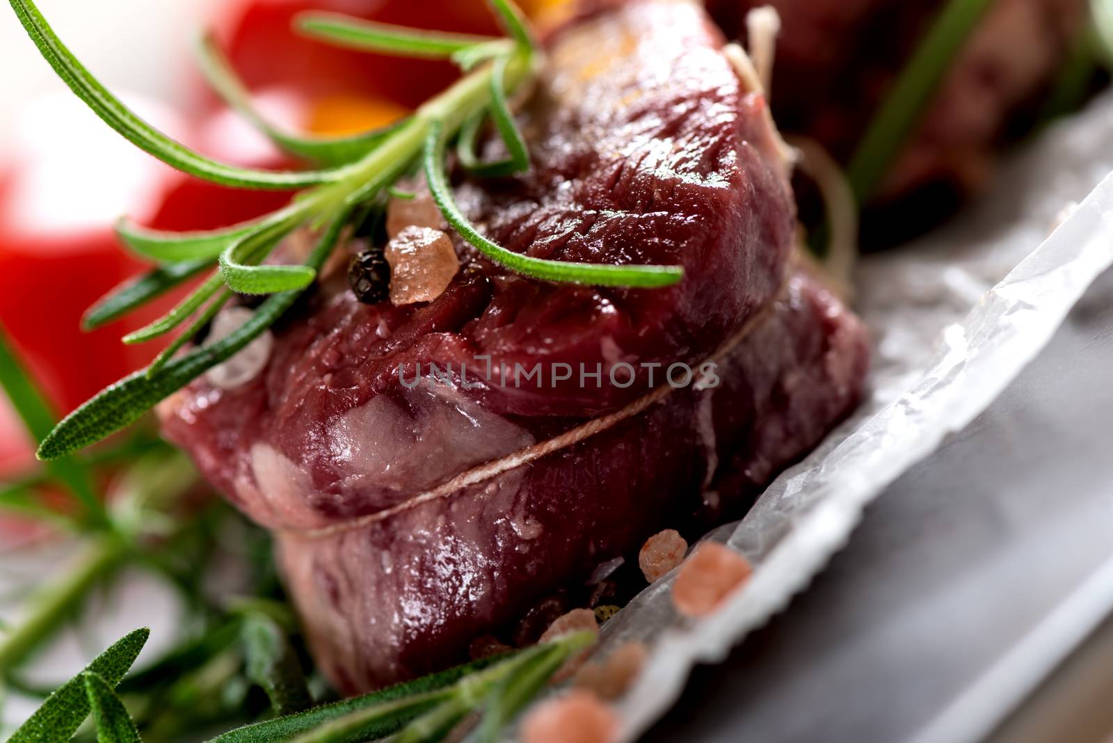 Raw beef steak with peppercorns and herbs by Nanisimova