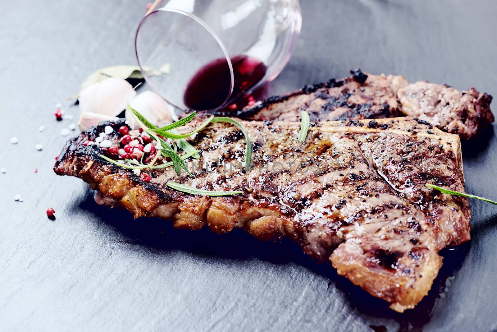 Steak with spices and glass of red wine by Nanisimova