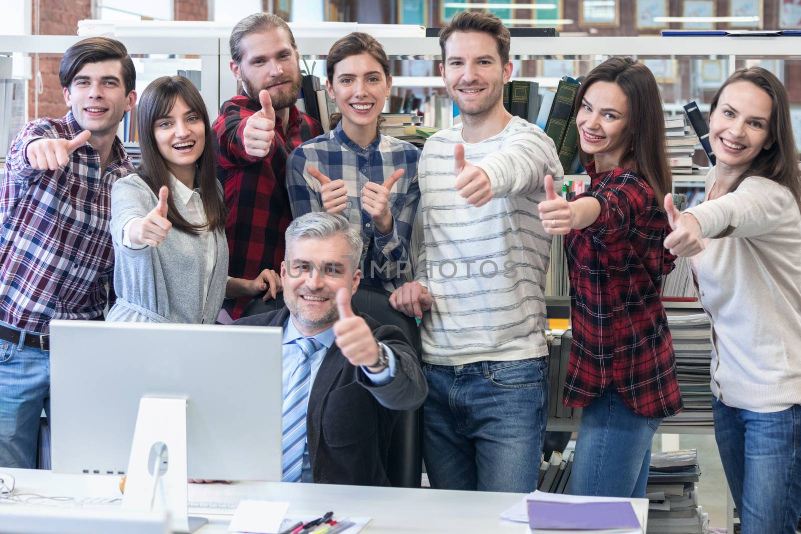 Group of business people in casual clothes with thumbs up at the office