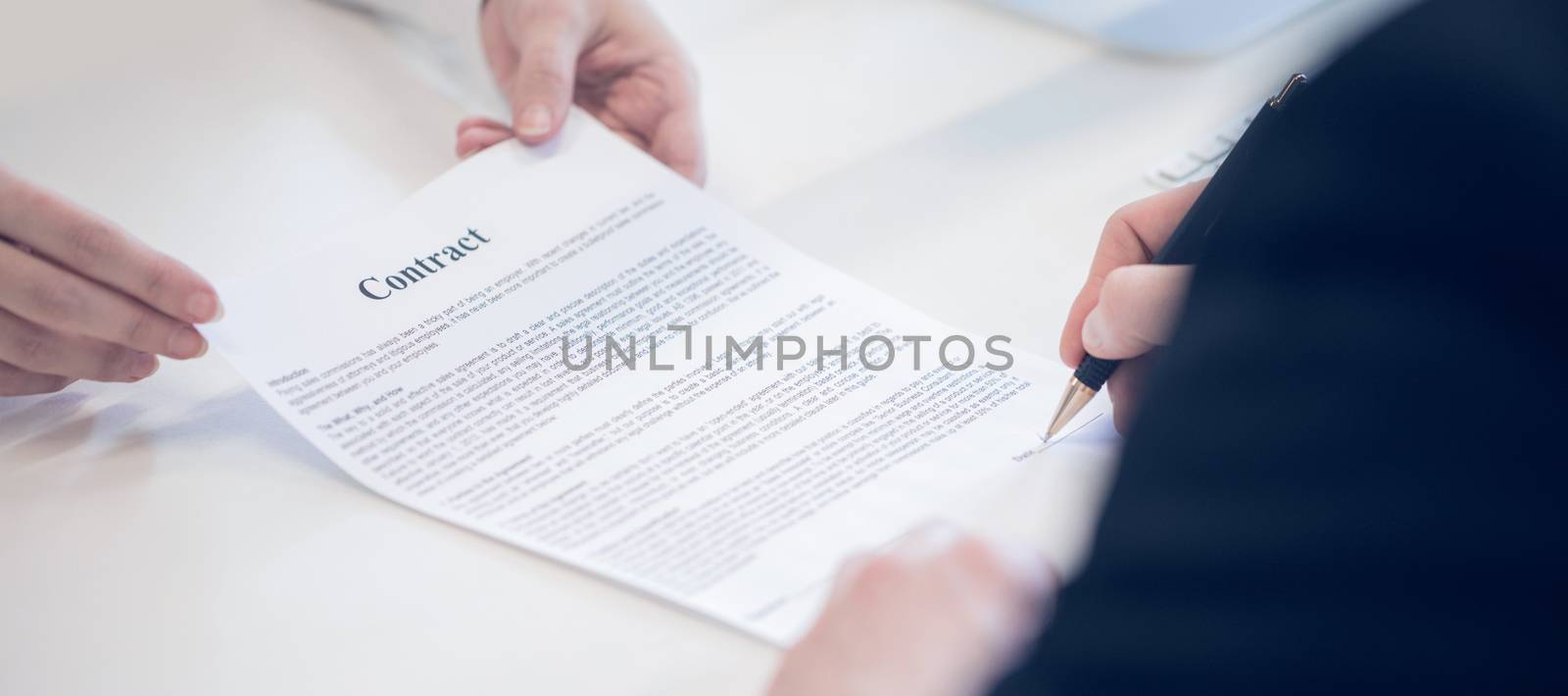 Closeup of woman hands giving businessman contract to sign