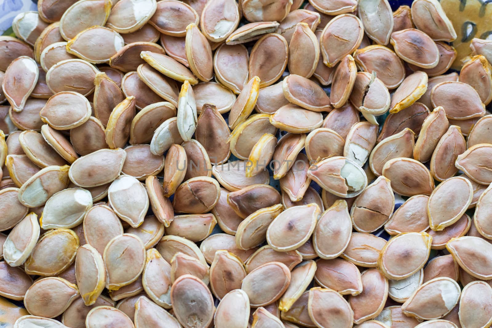 Close-up food background of dry fried yellow white pumkin seeds nuts