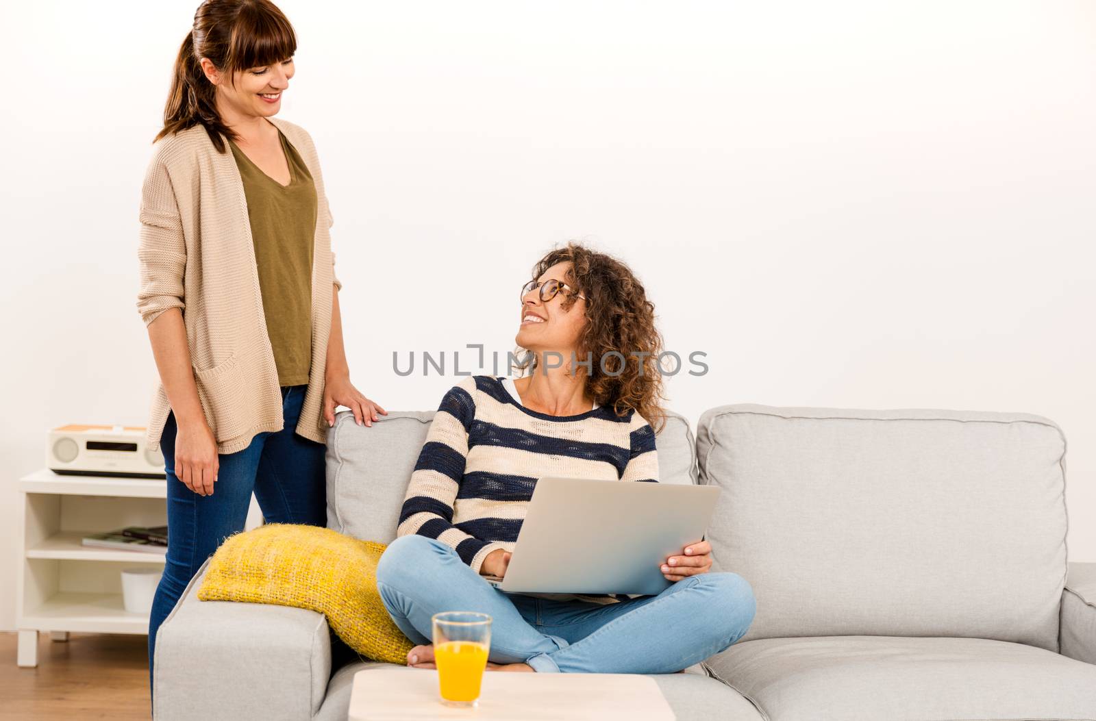 Two beautiful women at home working with a laptop