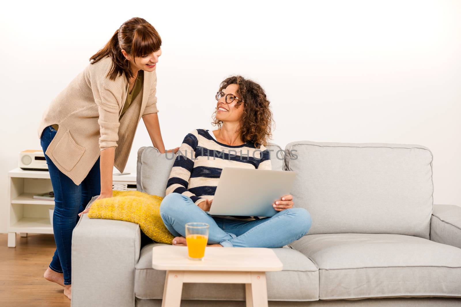 Two beautiful women at home working with a laptop