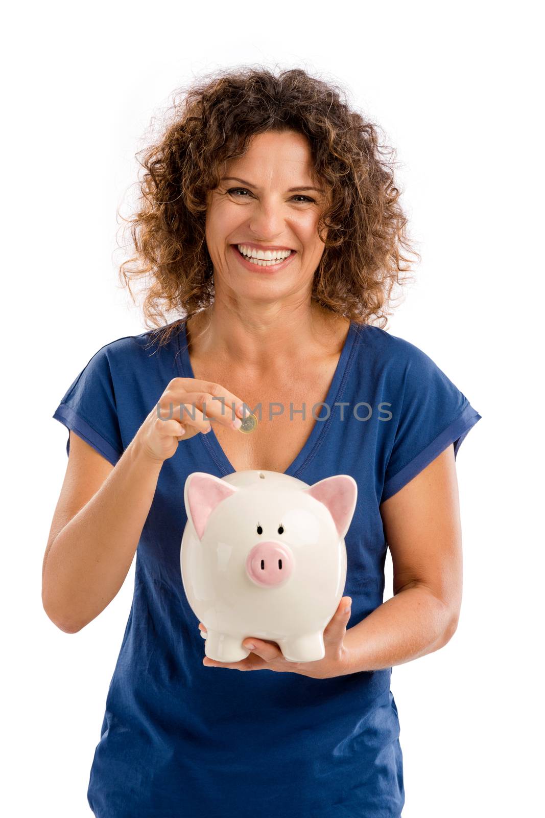 Portrait of a happy middle aged woman puting some money on a Piggybank