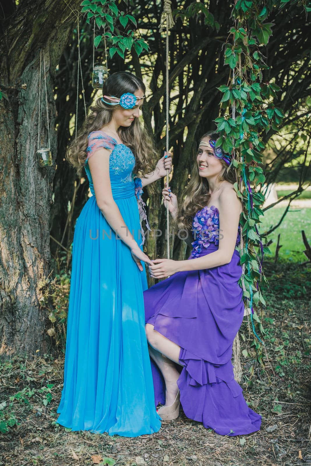 two adult sisters, twins in the summer garden