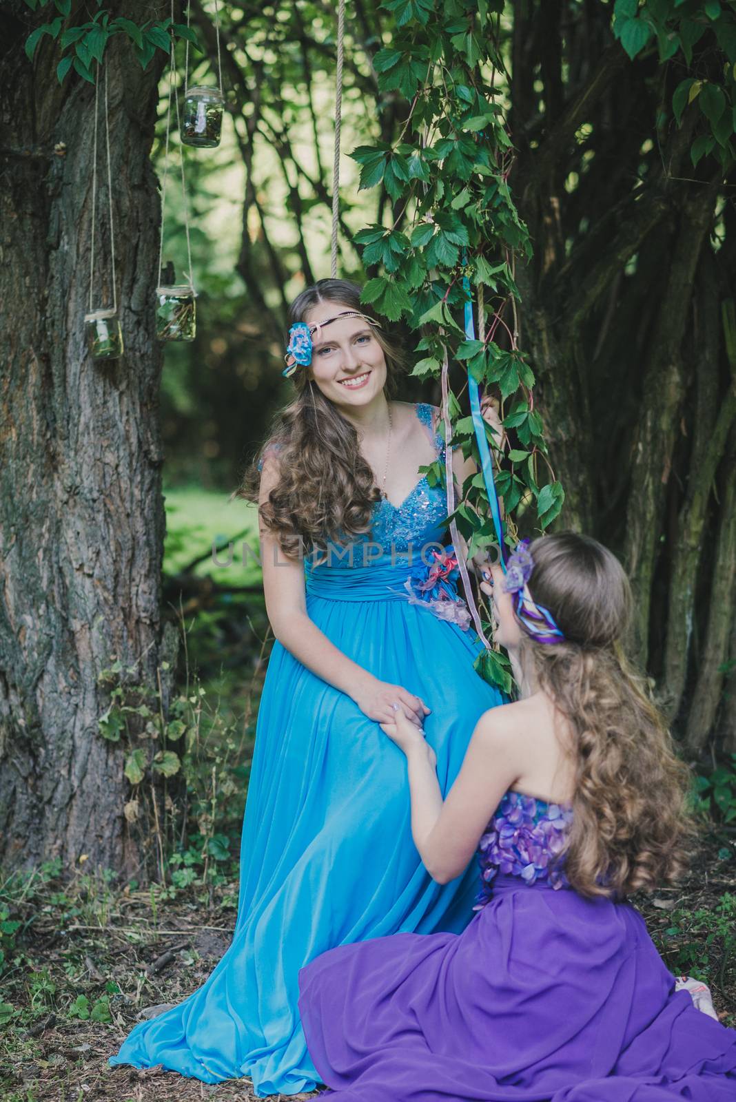 two adult sisters, twins in the summer garden