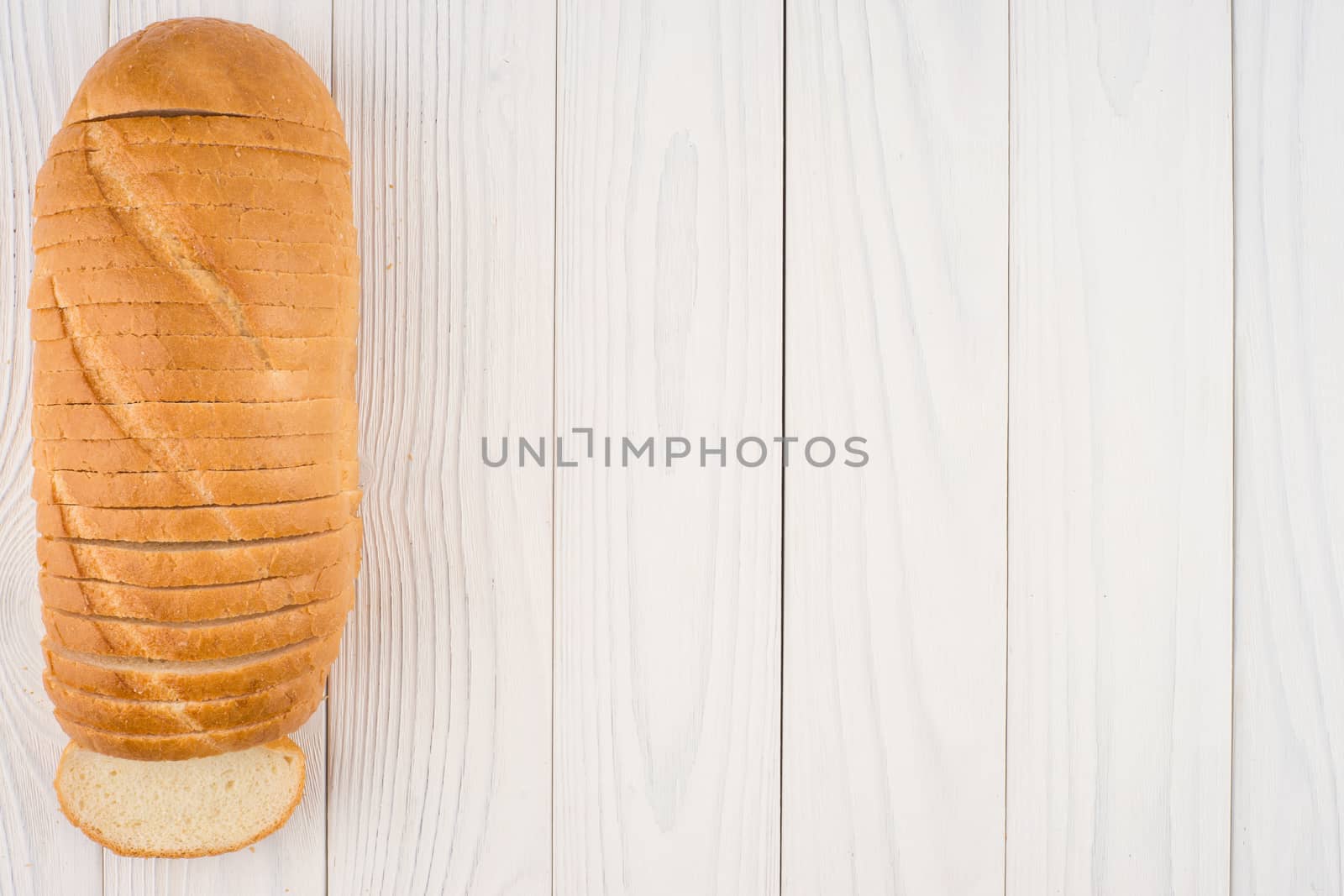 Loaf of bread on a wooden table. Top view.