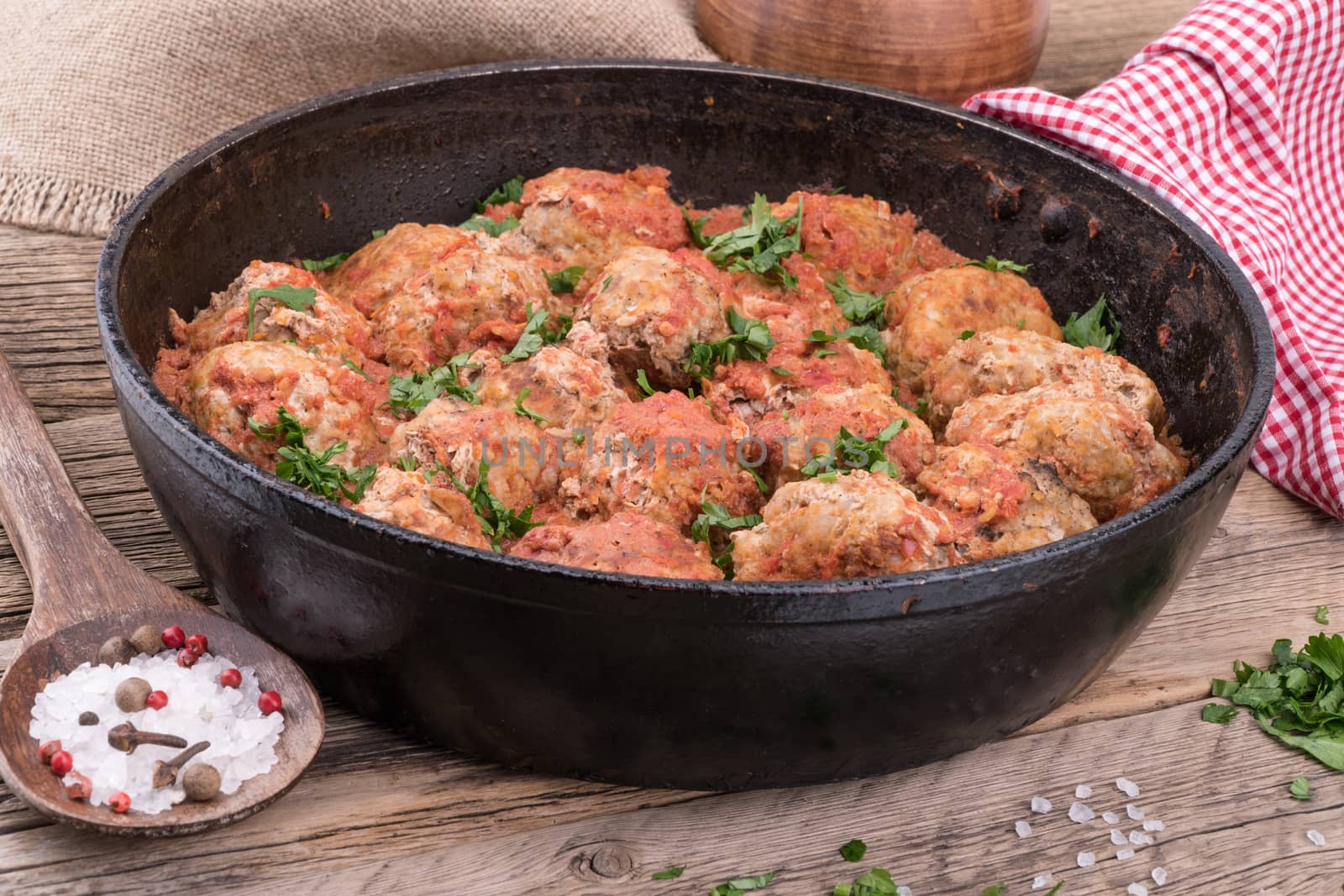 meat balls with herbs in pan on wooden rustic background. Selective focus.