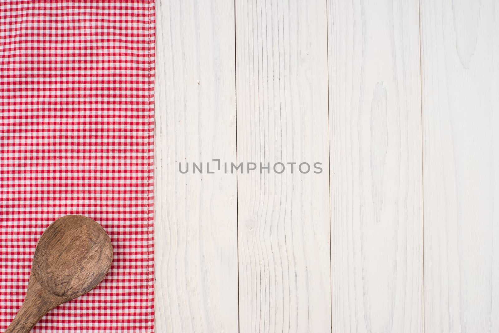 Wooden spoon on a napkin and old white wooden table.  by DGolbay