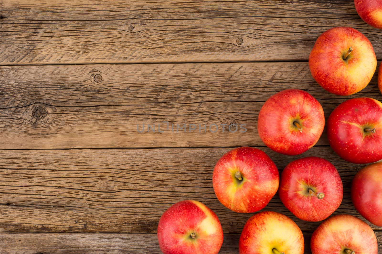 Red apples on the old wooden table.  by DGolbay