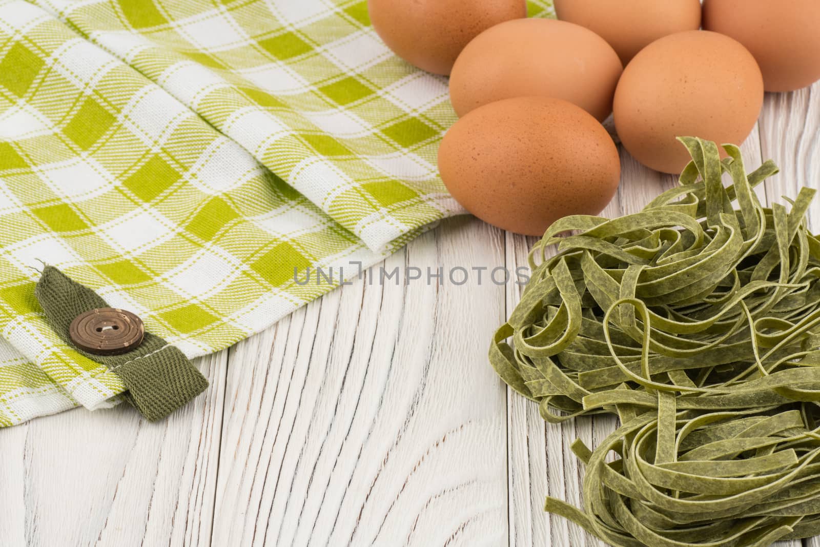 Raw green Italian pasta on old wooden table. Selective focus.