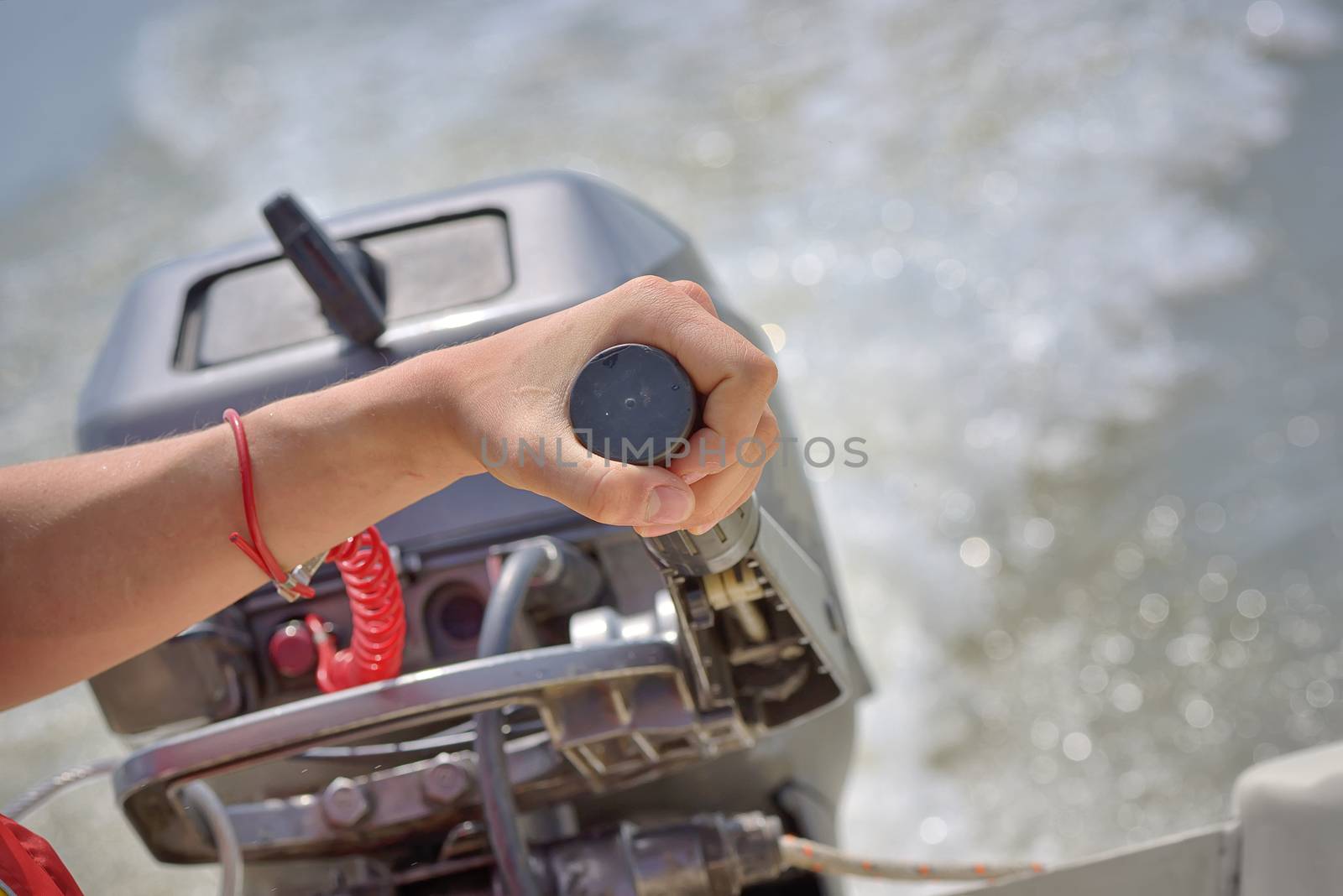 Fisherman hand and boat engine on river