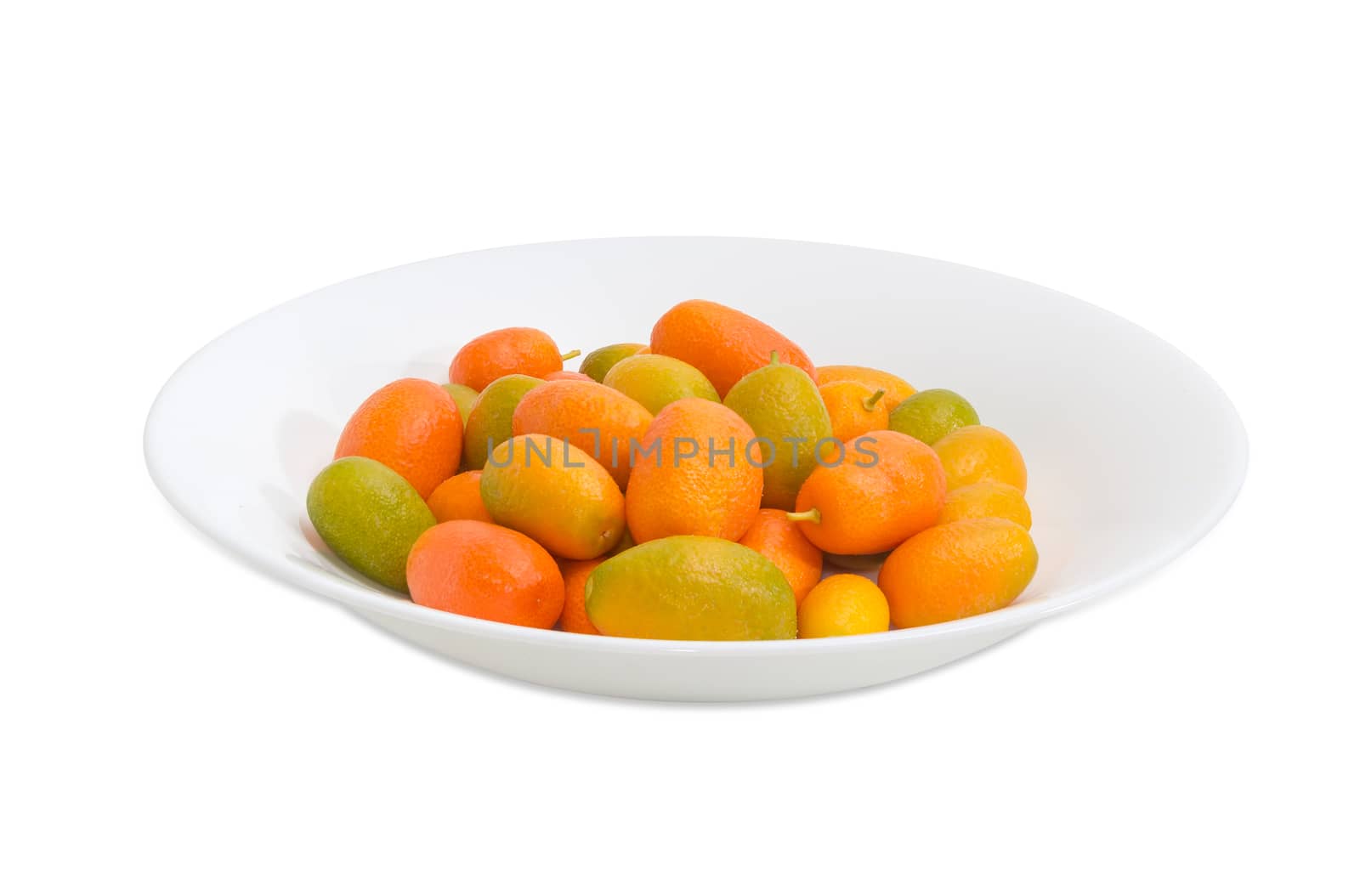 Fresh oval kumquats on a white dish on a light background
