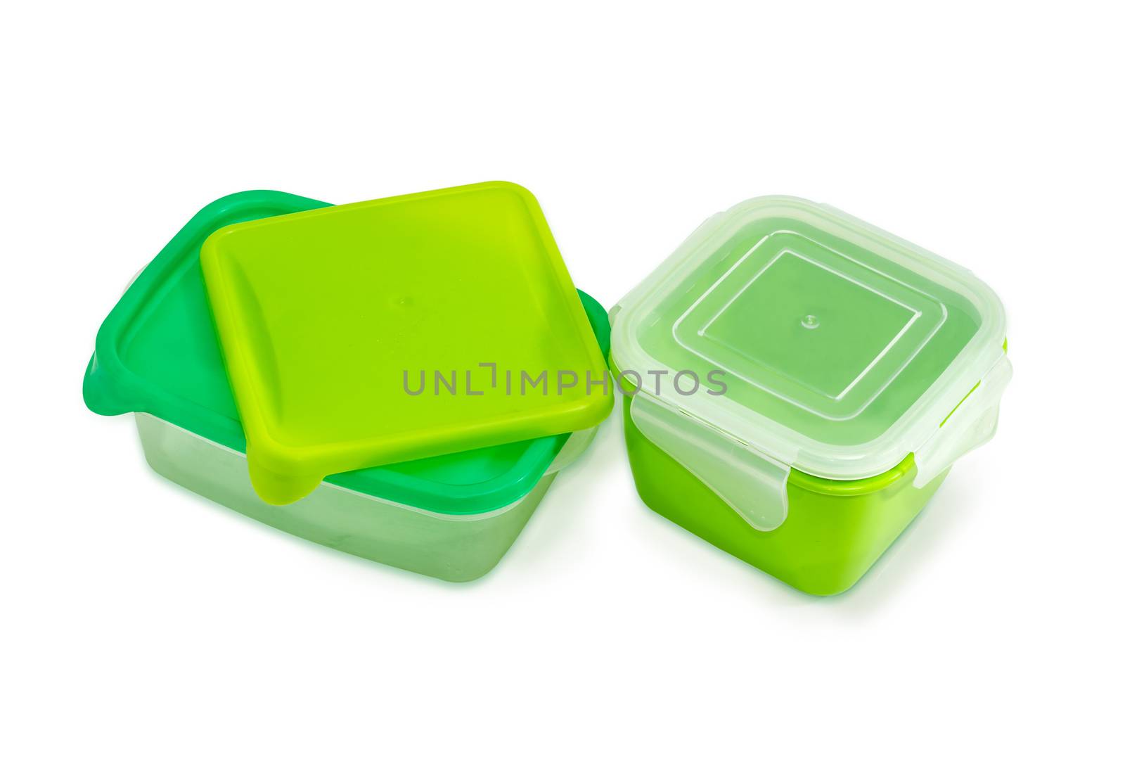 Two different green reusable plastic food storage containers with covers for home use on a light background
