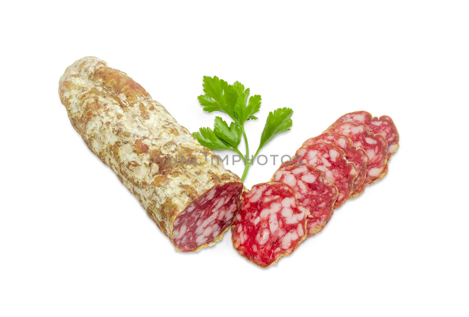 Partly sliced salami and twig of parsley on a light background
