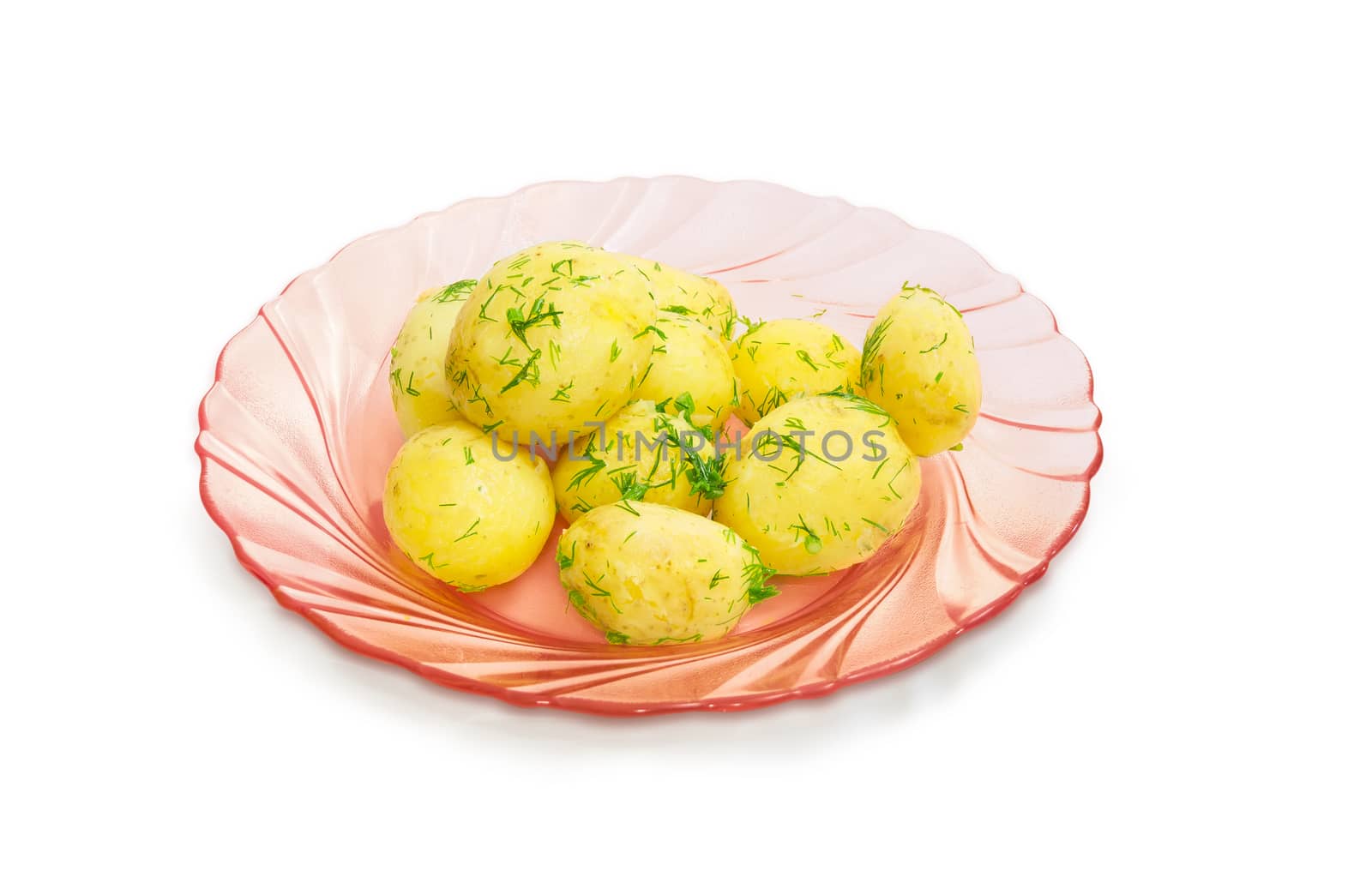 Boiled whole young potatoes of  early ripening with a butter, sprinkle with the chopped dill on the pink glass dish on a light background
