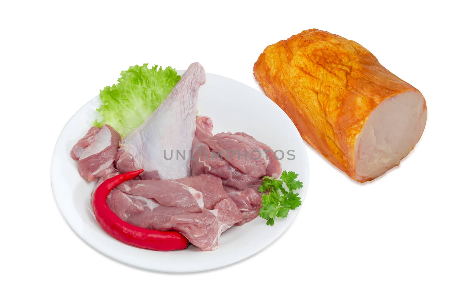 Uncooked turkey meat with herbs and chili on a white dish and piece of the cooked ham with turkeys beside on a light background
