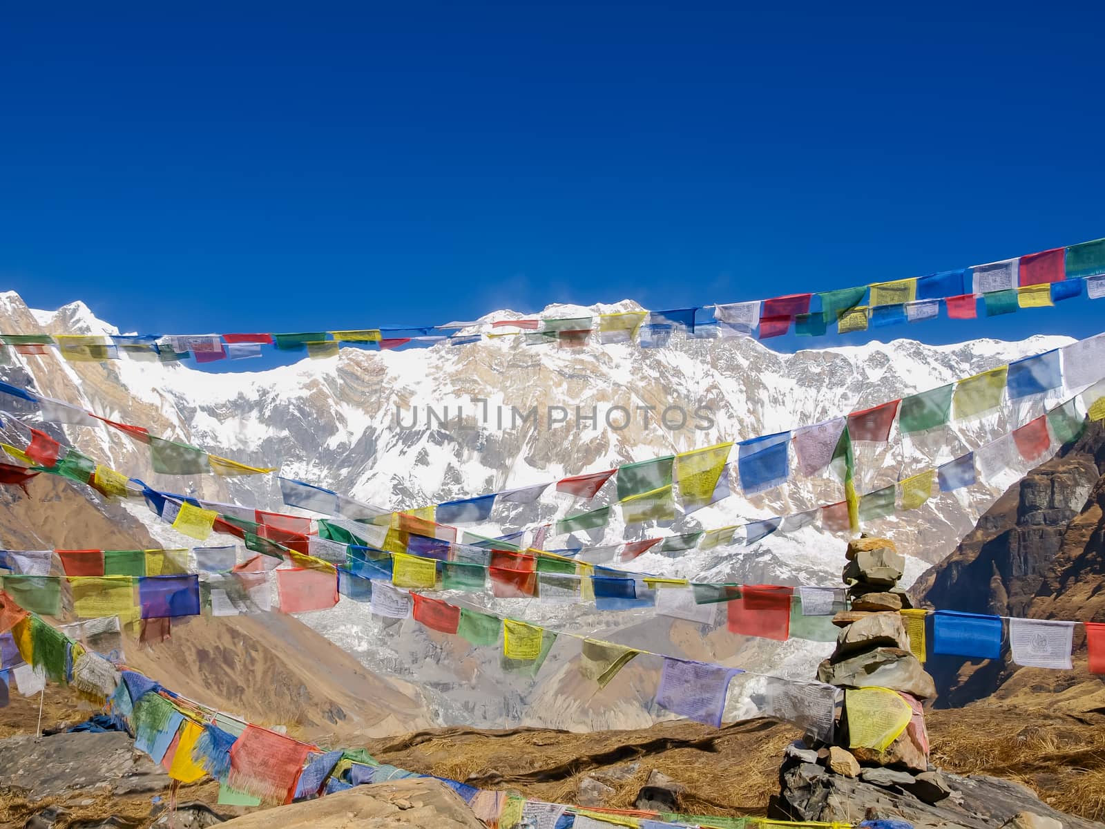 View of the south face of Annapurna I Main Mountain across the colorful prayer flags on the background of sky in morning in the Himalayas
