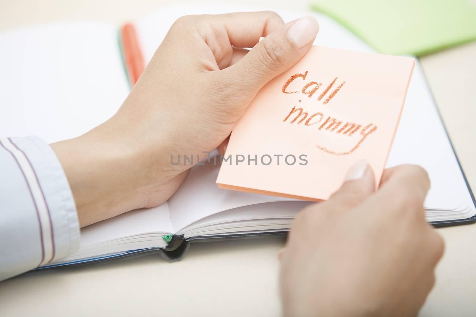 Hands holding sticky note with Call mommy text
