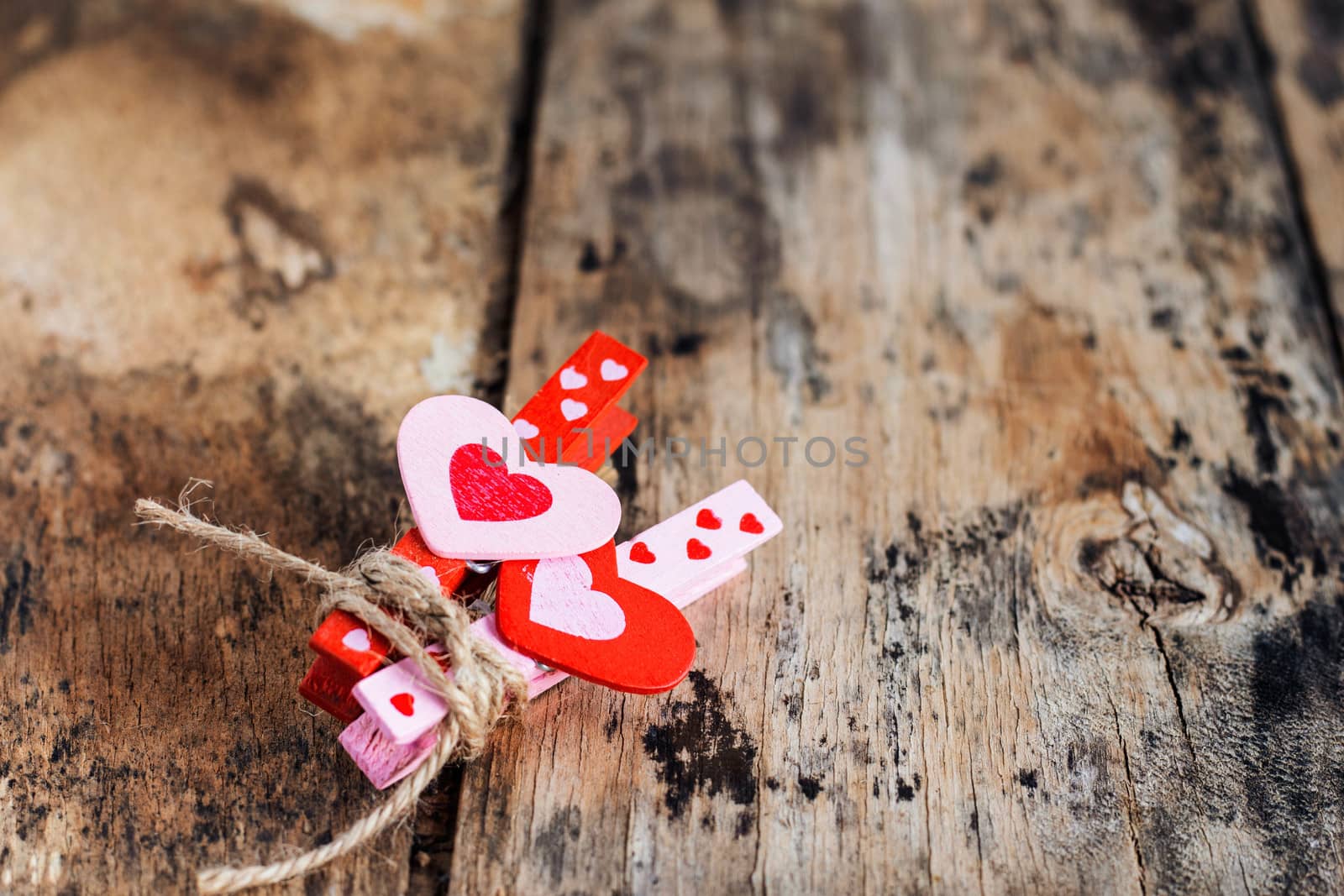 Heart tied with a rope on the old wooden floor.