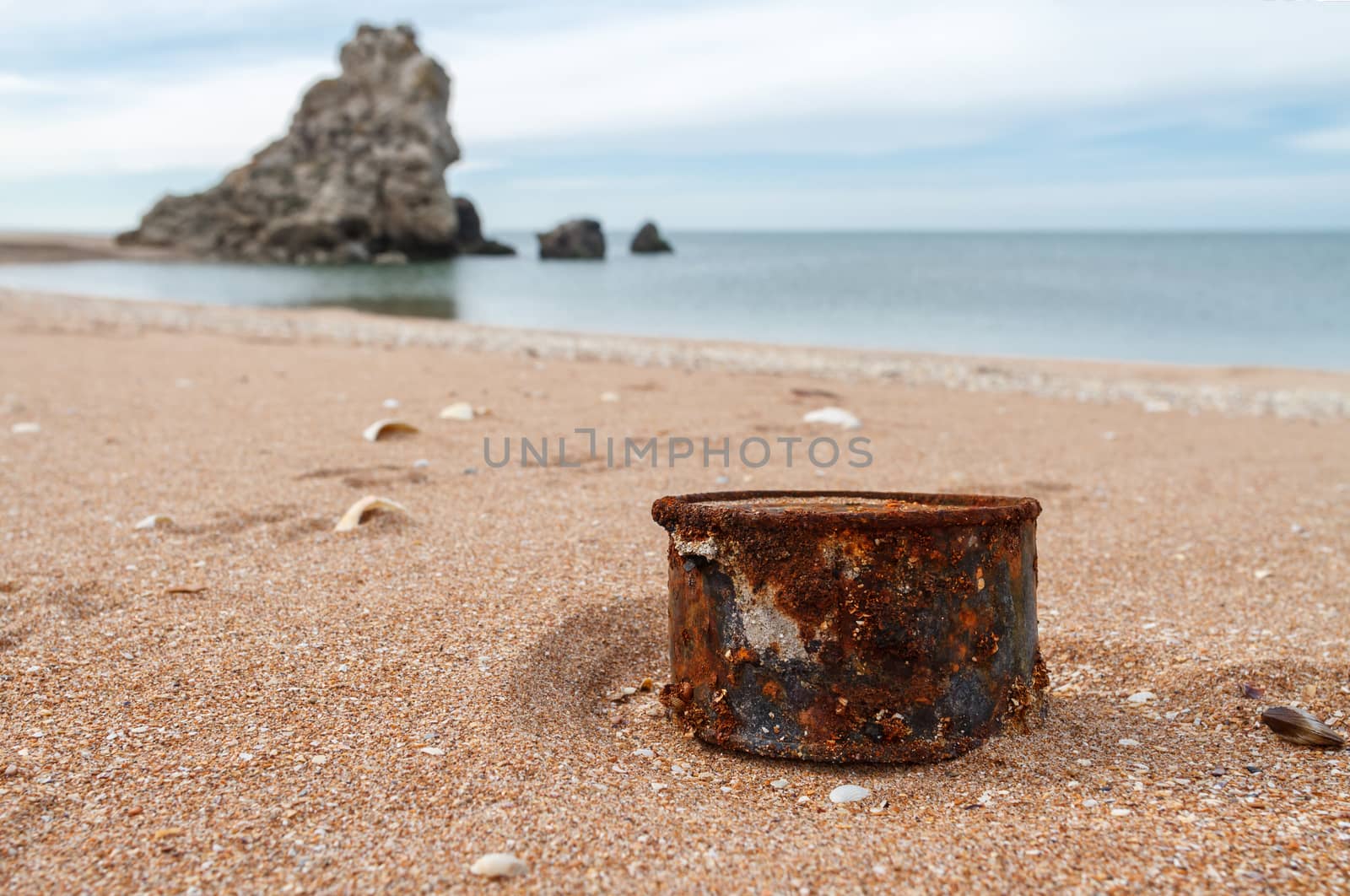 Rusty tin can on the beach by fogen