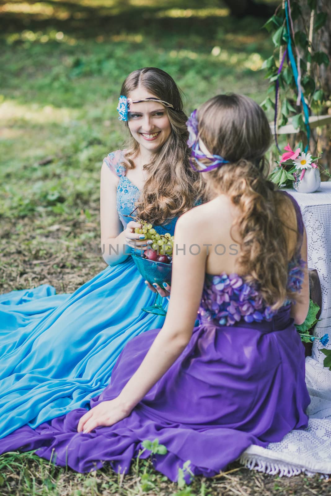 two adult sisters with fruit in the garden