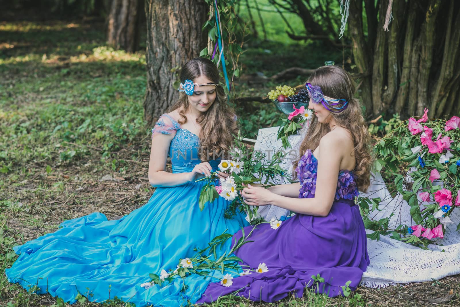 two adult sisters are twins with flowers in the garden