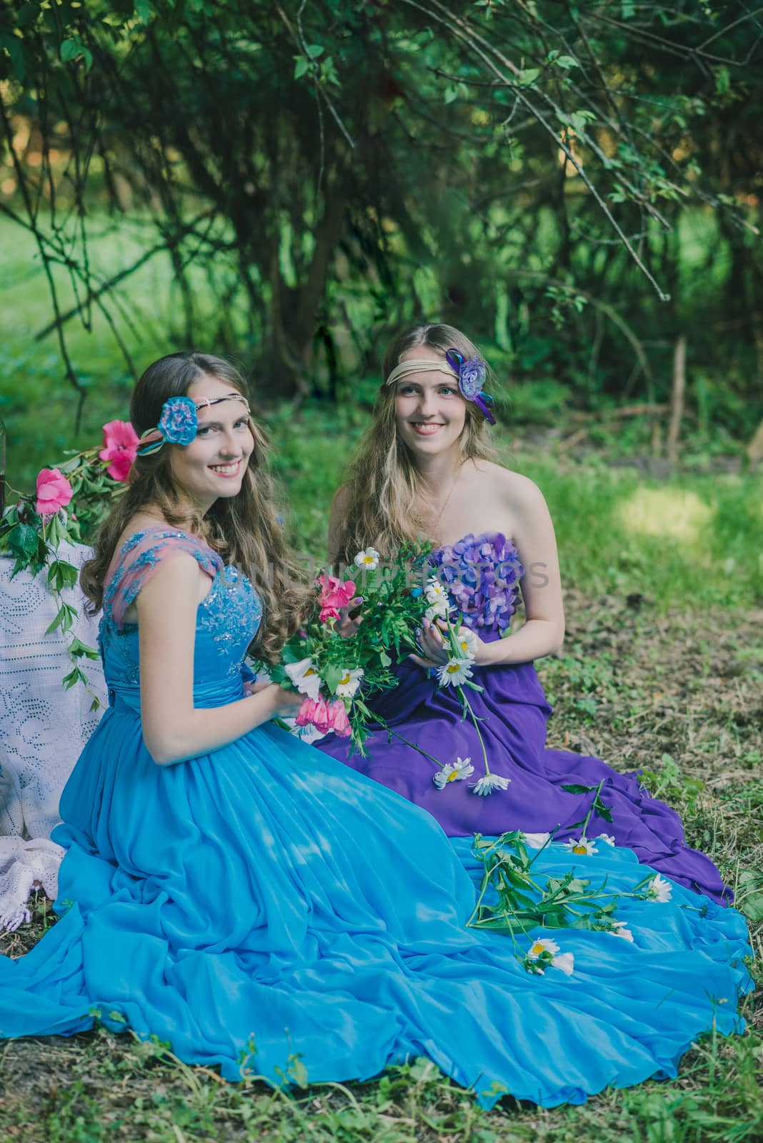 two adult sisters are twins with flowers in the garden