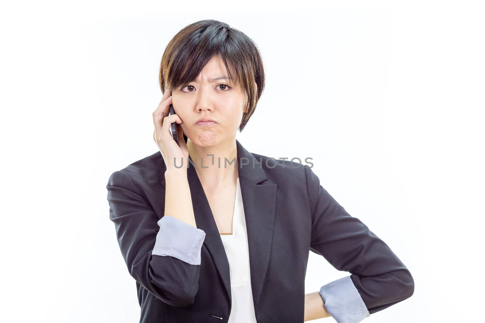 Chinese businesswoman in casual office clothes on cell phone looking annoyed