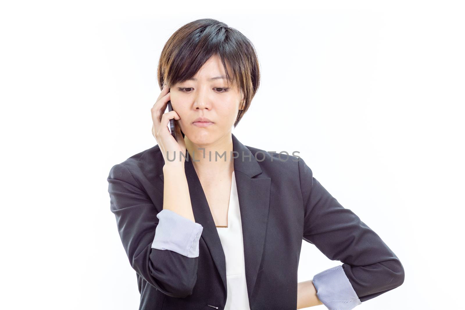 Chinese businesswoman in casual office clothes on cell phone looking annoyed