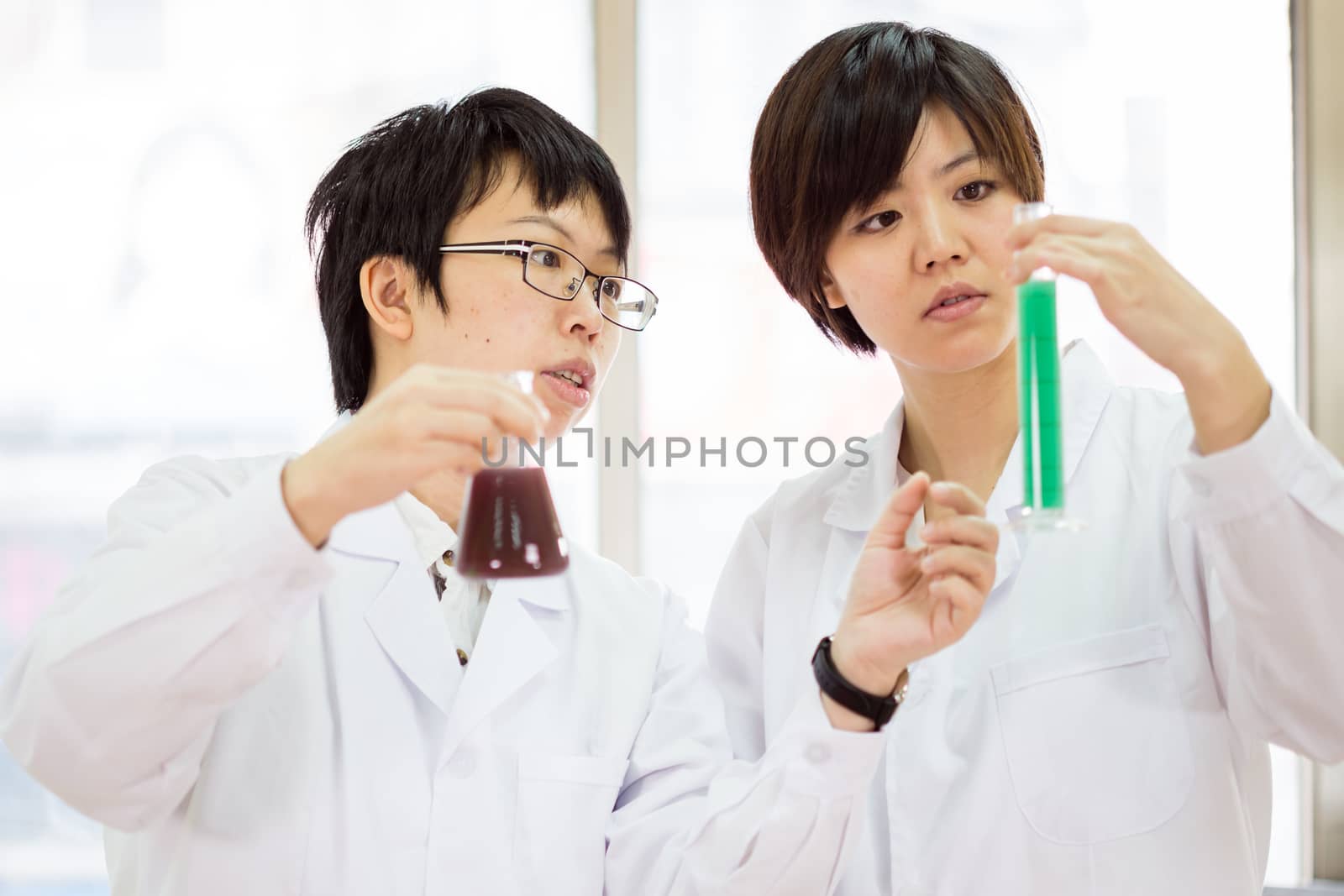 Female Chinese scientists in a laboratory inspecting chemicals