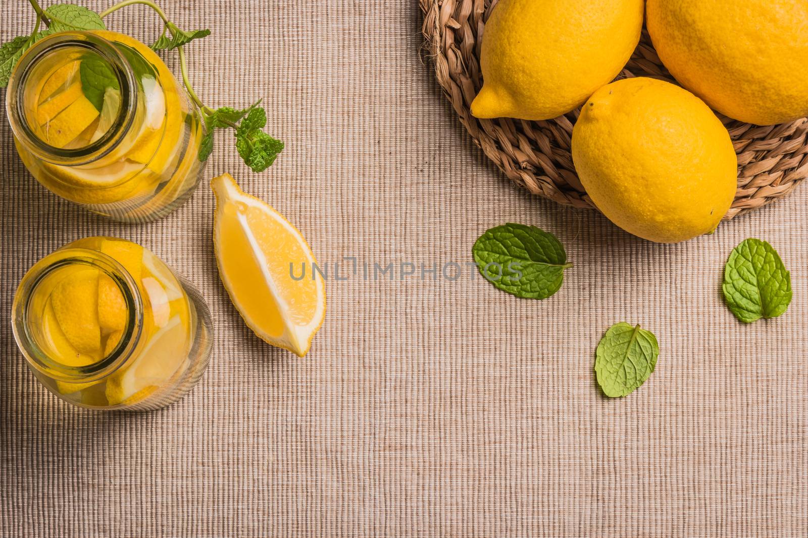 Glass of homemade lemonade with mint and lemon wedges. Top view with copy space.