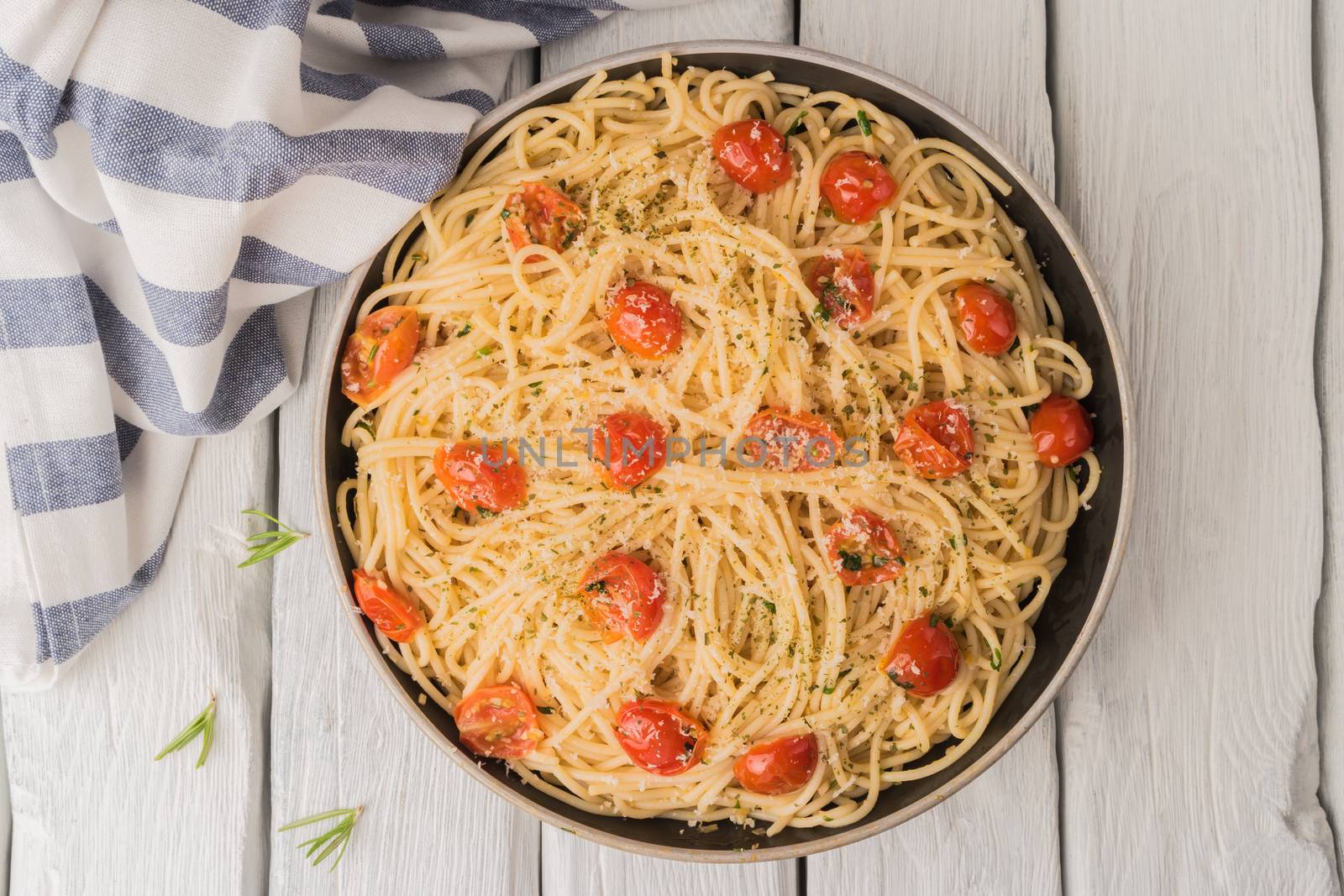 Spaghetti pasta with tomatoes and parsley on wooden table by AnaMarques