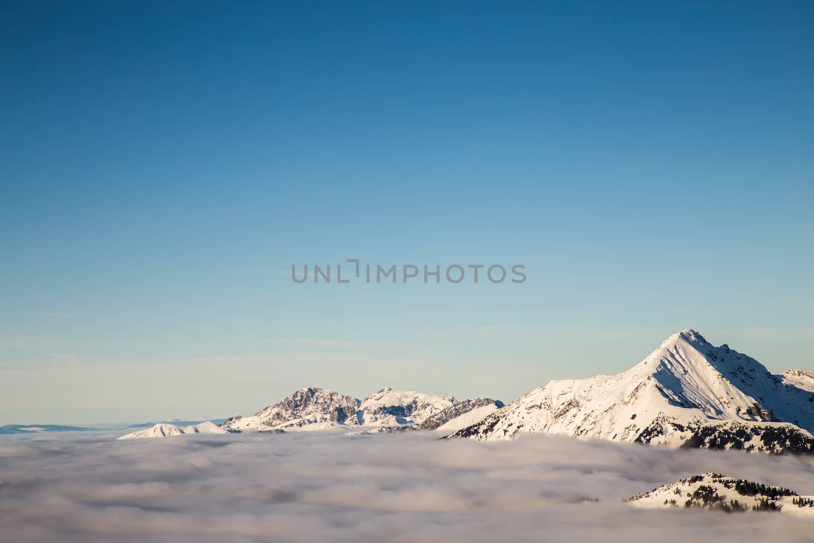 Mountains covered with snow and surrounded by clouds by kenzo85