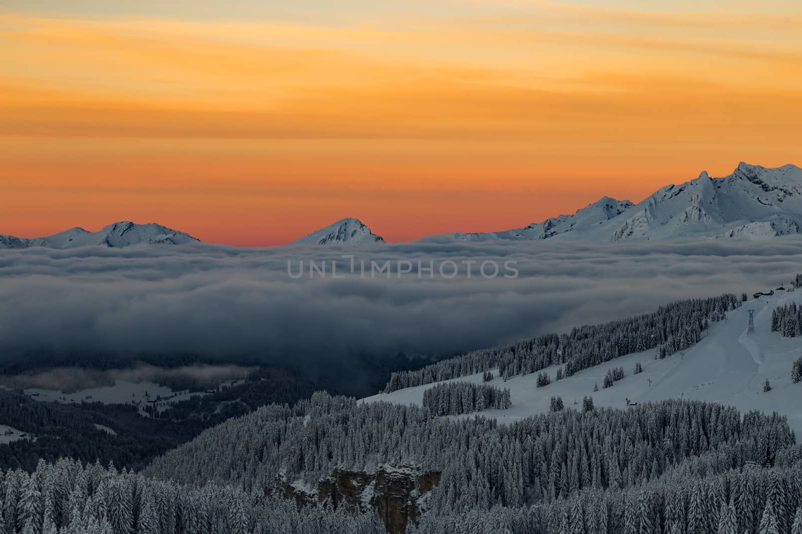 Mountains with a sunrise surrounded by cloudsin the Alps