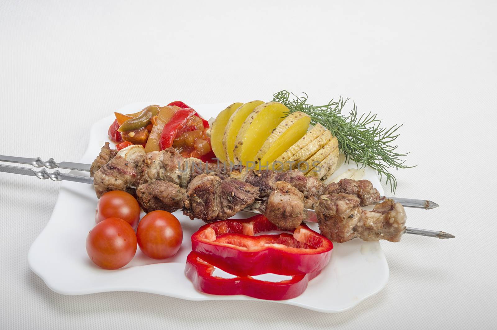 Kebabs grilled meat tomatoes and vegetables on white background 