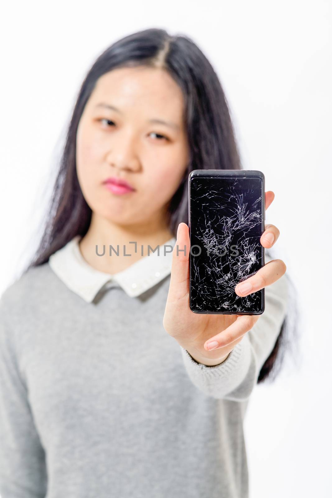 Upset Chinese schoolgirl with cracked cellphone