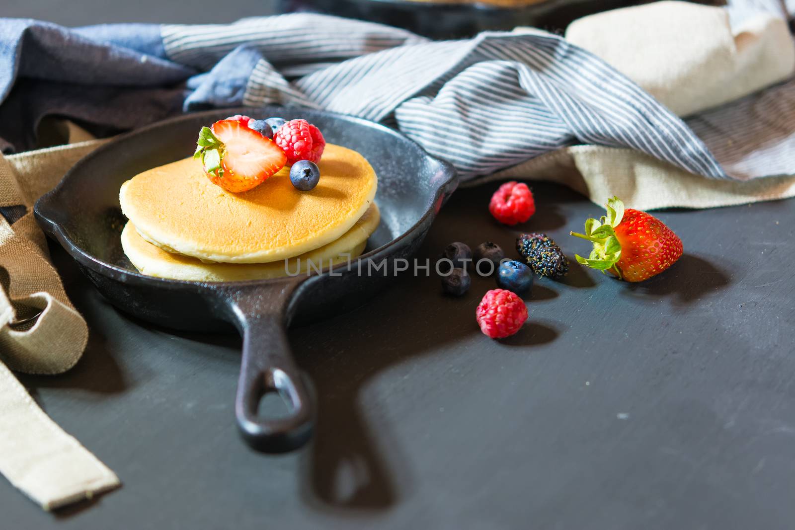 Pancakes with blueberries  & raspberry on wood background  by ahimaone